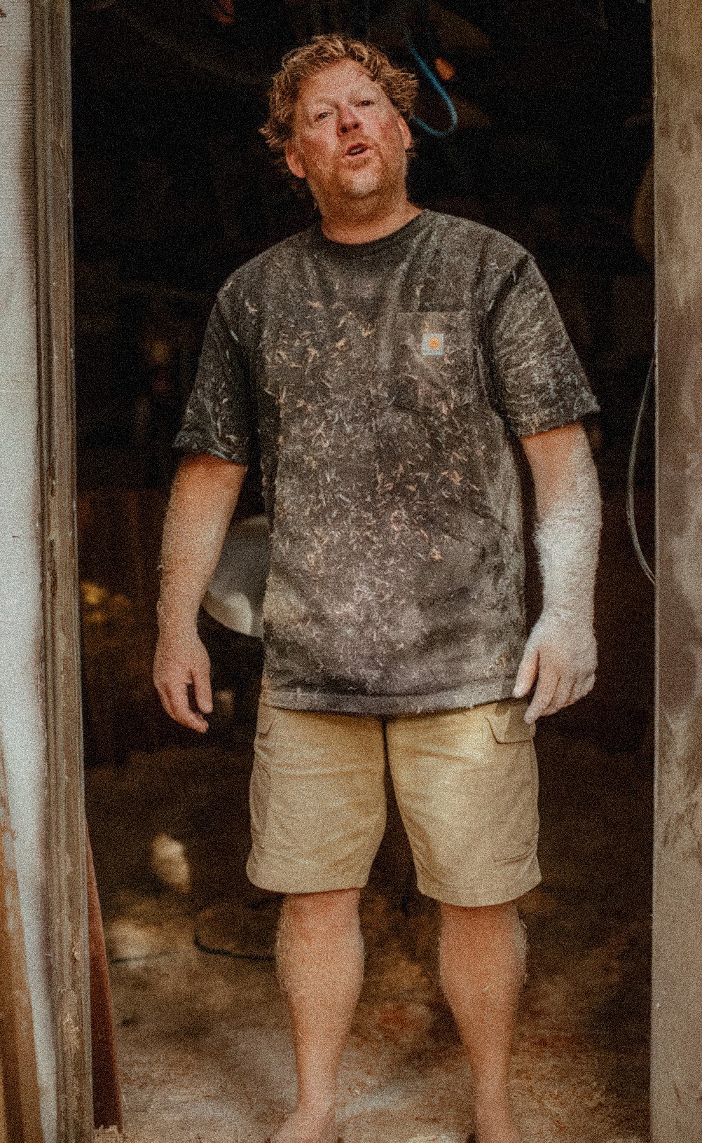 Joshua Martin covered in shaping dust at the entrance to his Capistrano Beach workshop